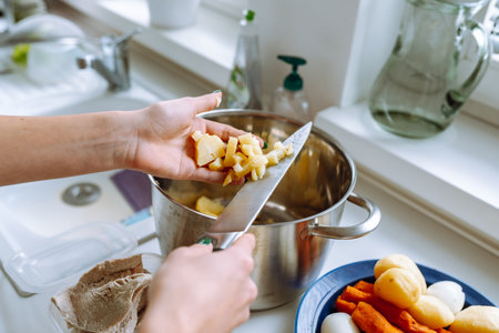 Hands cutting boiled vegetables into Olivier saladの写真素材