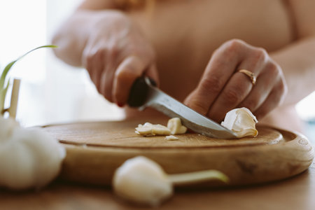 cooking, slicing garlic cloves on wooden cutting boardの写真素材