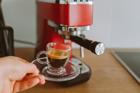 espresso coffee from coffee machine in transparent glass cupの写真素材