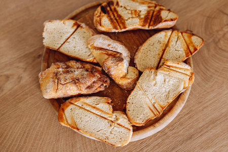 dried wheat bread, croutons, pieces, on a wooden round board