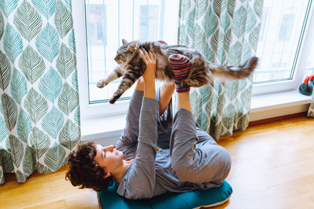portrait young woman doing yoga with catの写真素材