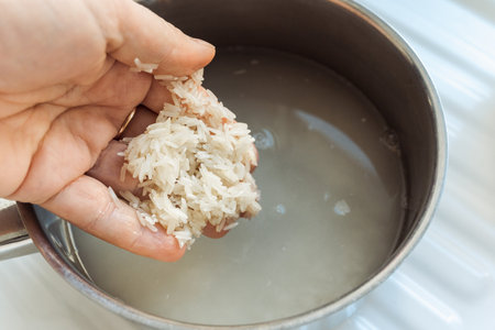 Woman rinsing rice under running water, closeupの写真素材