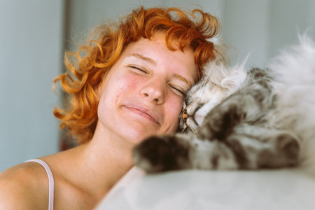 portrait red-haired teenage girl with gray fluffy catの写真素材