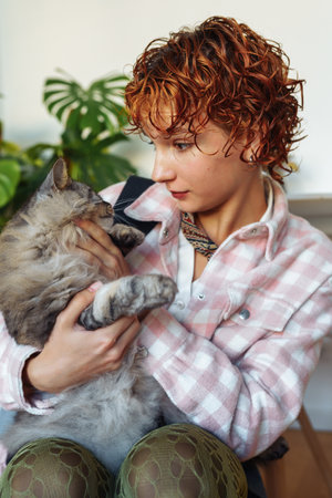 portrait of red-haired attractive young woman with grey big cat