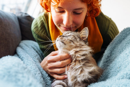 portrait red-haired attractive young woman with fluffy big catの写真素材