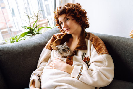 portrait young woman hugging gray fluffy domestic cat