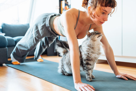 young woman doing yoga with her pet cat