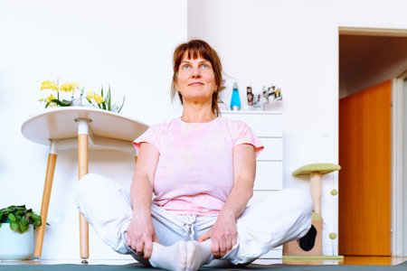 middle aged woman doing yoga at home