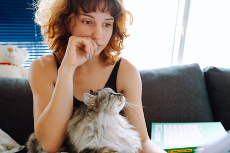 young woman spending time with her catの写真素材