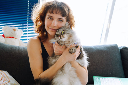 young woman spending time with her catの写真素材