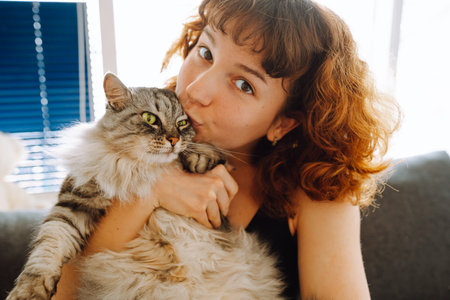 young woman spending time with her catの写真素材