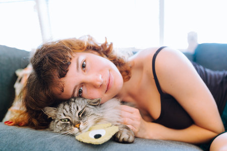 portrait domestic pedigree fluffy cat with young womanの写真素材