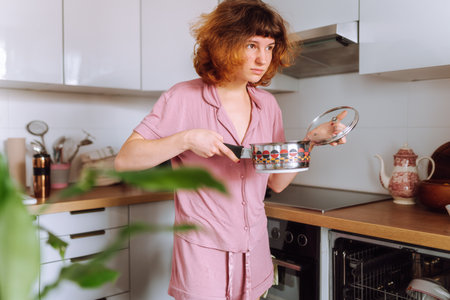 young woman using dishwasher in home kitchen