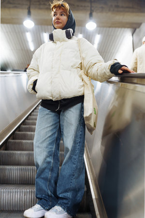 young woman in white winter jacket in the underground metroの写真素材
