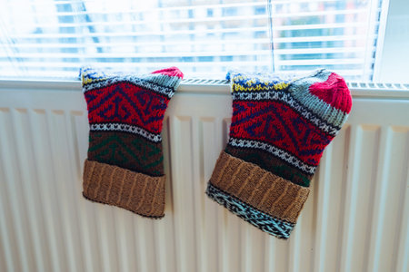 Woolen socks dry on radiator on cold winter day.