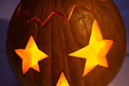 Single Halloween pumpkin with burning eyes - stars on a dark backgroundの写真素材