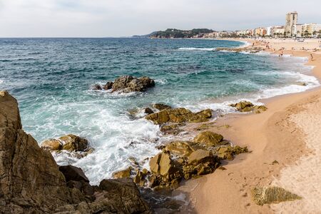Cliffs and sandy beach of Lloret de mar, Catalonia, Spain. Summer is a sunny day.