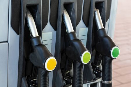 Three fueling pistols at a gas station for cars. Close-up.