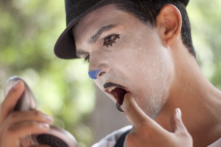 NITEROI, BRAZIL - MAY 6, 2012  guy making up himself before taking part on a street parade