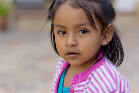 SUCRE, BOLIVIA - JANUARY 17, 2012  A young girl faces the camera while playing in the street  January 17, 2012 in Sucre, Bolivia  Bolivia is inhabited mostly by Quechua and Aymara decendantsのeditorial素材