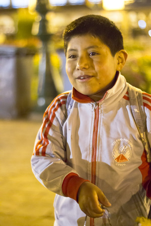 CUZCO, PERU - JUNE 3, 2013: A street vendor boy smiles while working trying to sell key chains around the main square of the town. June 3, 2013 in Cuzco, Peru.のeditorial素材