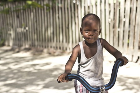 CAYE CAULKER, BELIZE - SEPTEMBER 20, 2013: Boy tries to learn how to ride a bike September 20, 2013 in Caye Caulker, Belize. Belize is considered the 4th happiest country in the worldのeditorial素材