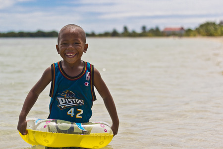 PLACENCIA, BELIZE - SEPTEMBER 22, 2013: Kid playing in the sea with his float. September 22, 2013 in Placencia, Belize. Belize is considered the 4th happiest country in the worldのeditorial素材
