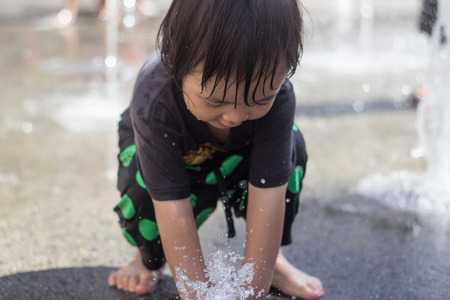LOS ANGELES - SEPTEMBER 6, 2014: Asian boy playing in the water to avoid summer heat. September 6, 2014 in Los Angeles.のeditorial素材