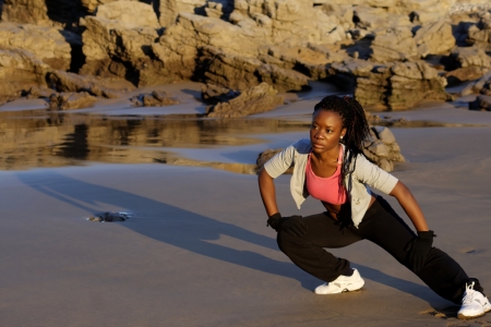 black woman stretching on the beachの写真素材