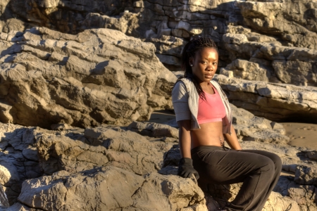 black woman leaning against a rockの写真素材