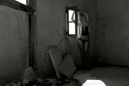 blonde girl posing in lingerie in ruined houseの写真素材