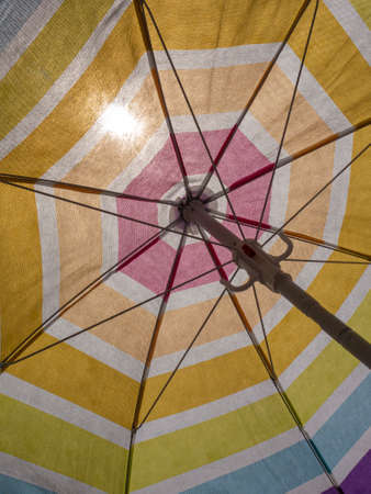 beach umbrella in the summer of spain with multi coloredin a blue skyの写真素材