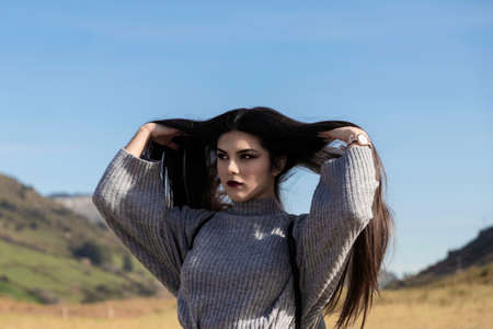 pretty brunette girl with very long hair over a blue skyの写真素材