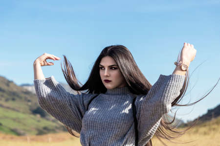 pretty brunette girl with very long hair over a blue skyの写真素材