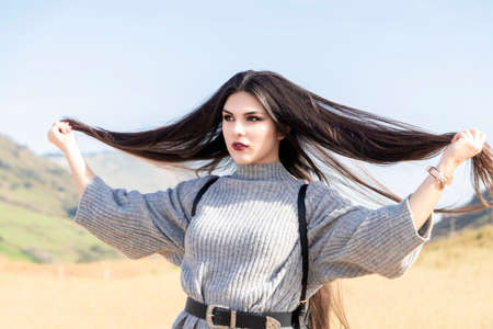 pretty brunette girl with very long hair over a blue skyの写真素材
