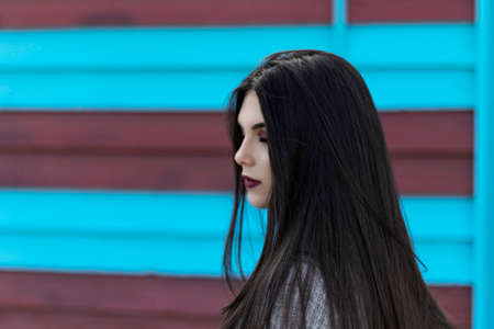 portrait of young long brunette hair brunette woman with brown eyes with a blue and red background