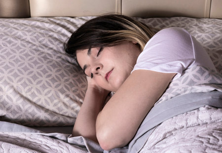 young woman in white t-shirt sleeping in bed