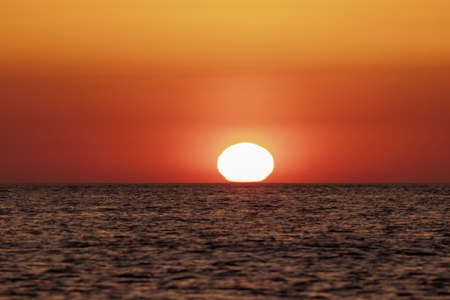 sun at sunrise in the Mediterranean sea on a summer dayの写真素材