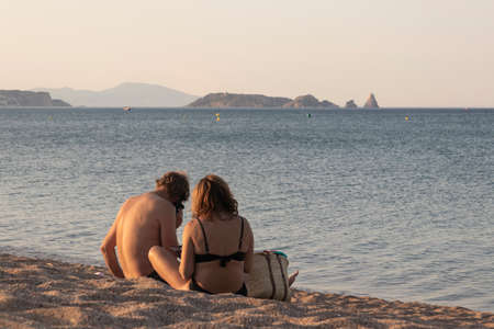 couple embracing on the beach on a summer day at sunsetの写真素材