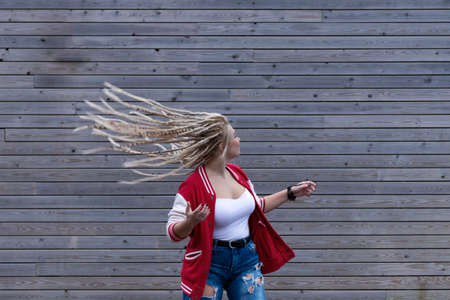 blonde woman with dreadlocks wagging her hairの写真素材