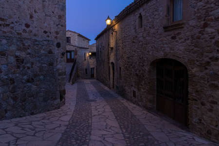 stone street in the medieval village of pals at nightの写真素材