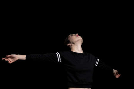 woman opening her arms happy on black background
