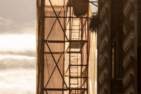 scaffolding on a backlit building in the city of bilbaoの写真素材