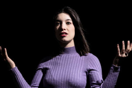 resigned brunette woman on black background
