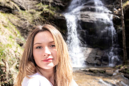portrait of pretty blonde woman in a waterfallの写真素材
