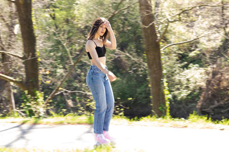 brunette woman with pink roller skates in the park