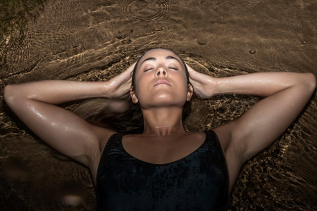 woman lying in the sea at night in a bathing suit
