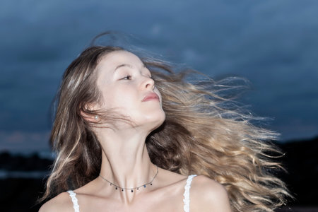 Smiling sexy blonde tossing her hair on a beautiful wild beachの写真素材
