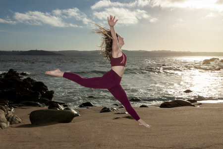 Woman Jumping In The Air On Beach