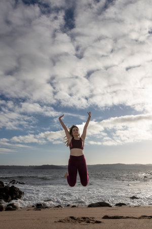 Woman Jumping In The Air On Beachの写真素材
